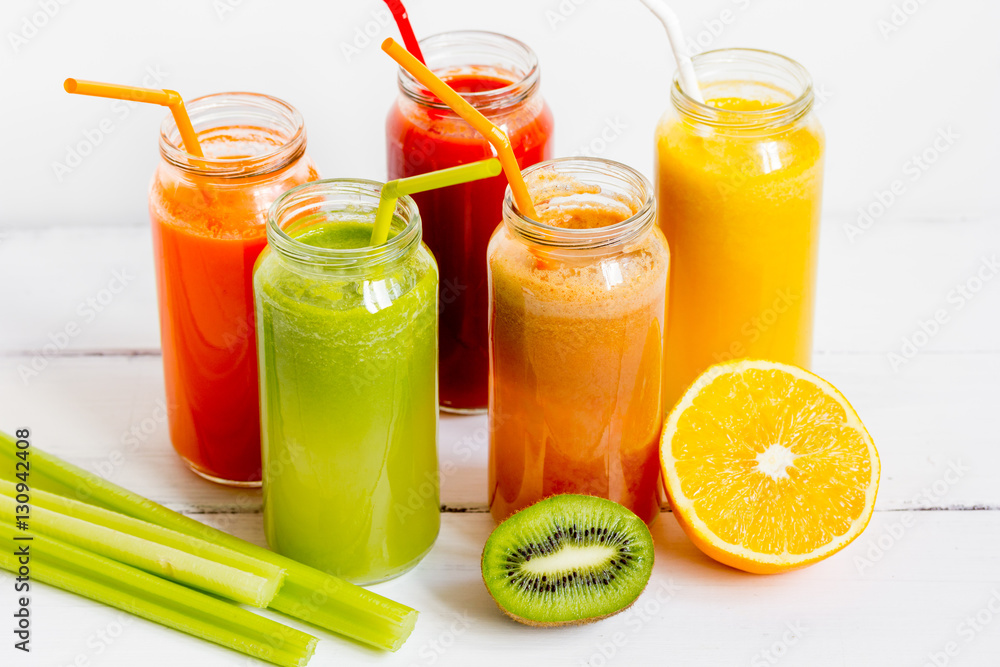 Fresh detox juices in glass bottles on white background