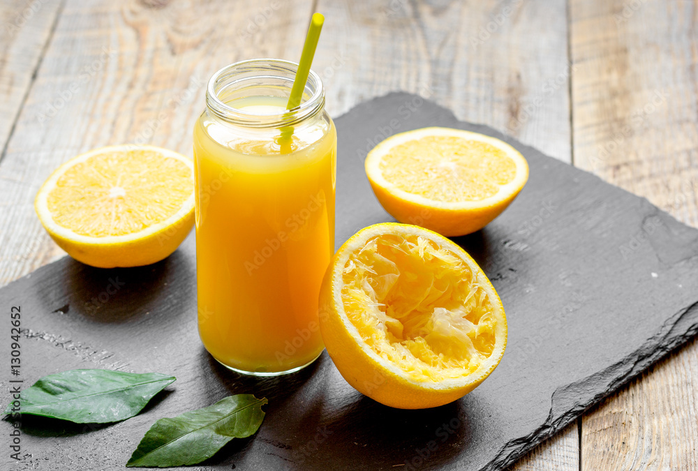 freshly squeezed orange juice in glass bottle on wooden background