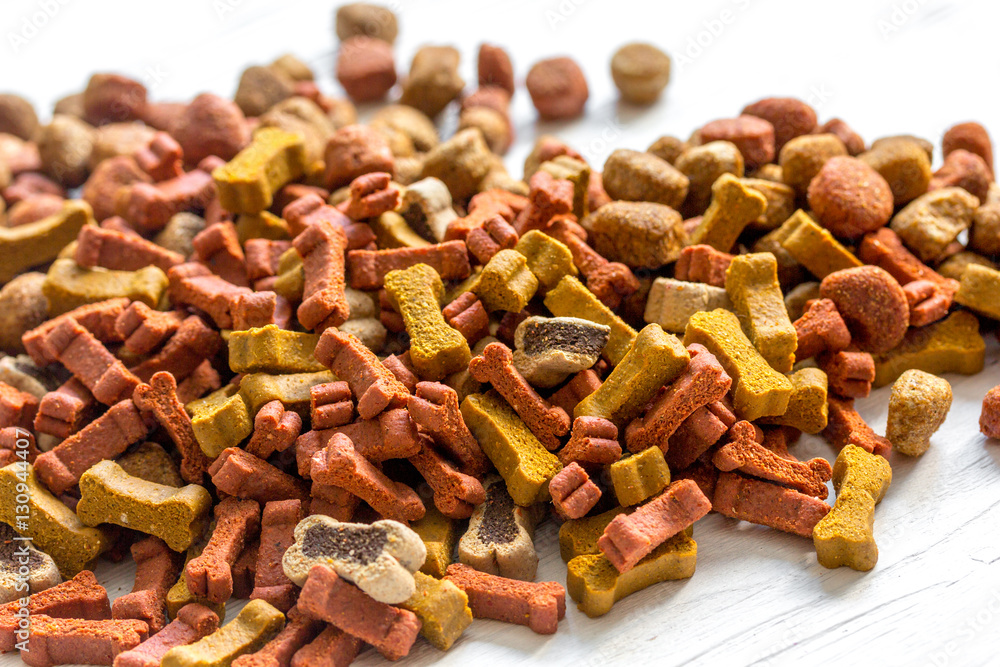 dry dog food in bulk on wooden background close up