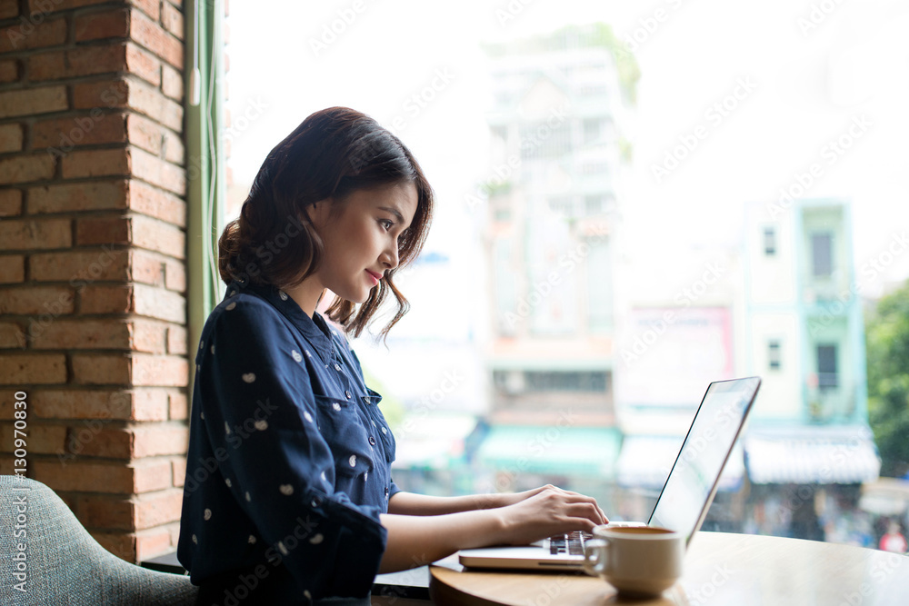 Beautiful cute asian young businesswoman in the cafe, using lapt