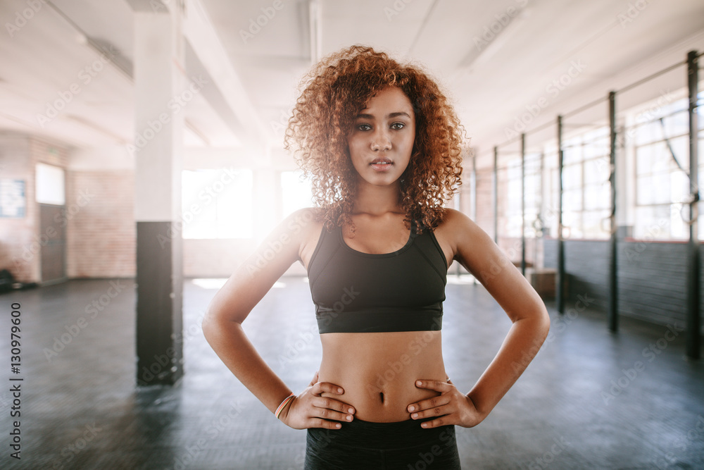 Fit young african woman standing in gym