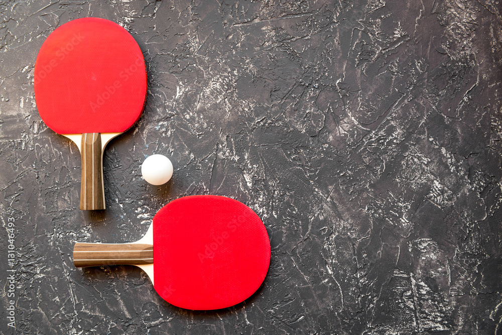 Red racket for ping pong ball gray background top view