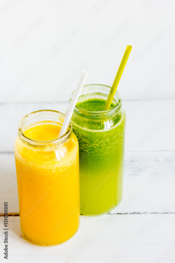 Fresh detox juices in glass bottles on white background