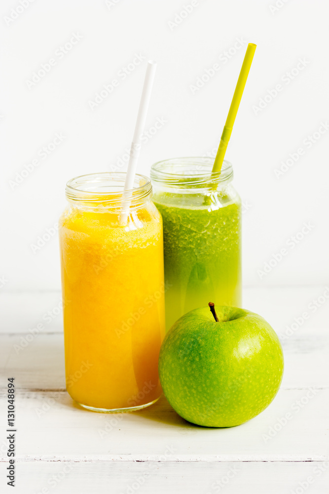 Fresh detox juices in glass bottles on white background