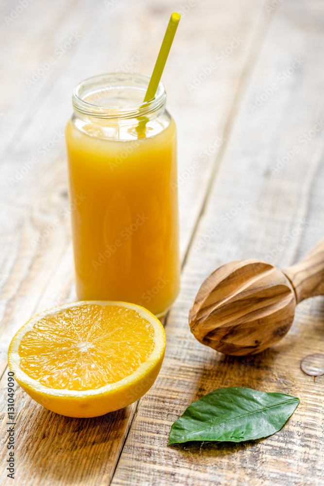 freshly squeezed orange juice in glass bottle on wooden background