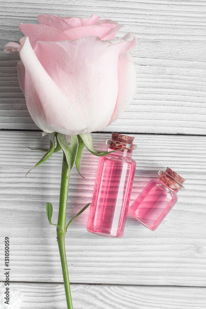 organic cosmetic with rose oil on wooden background top view