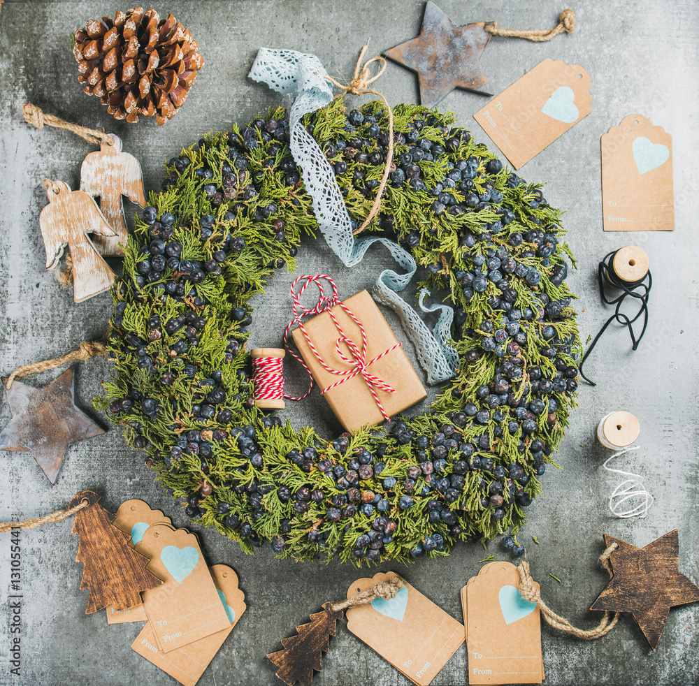 Christmas decorative green wreath with fresh blueberries and natural herbs, wooden toys, presents an