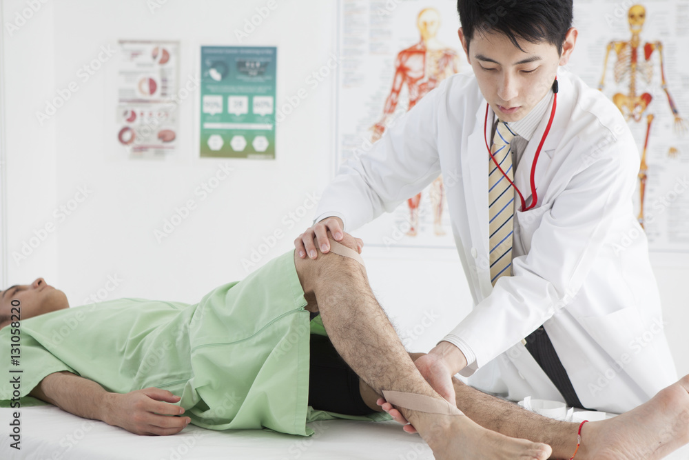 The doctor is examining the legs of a man