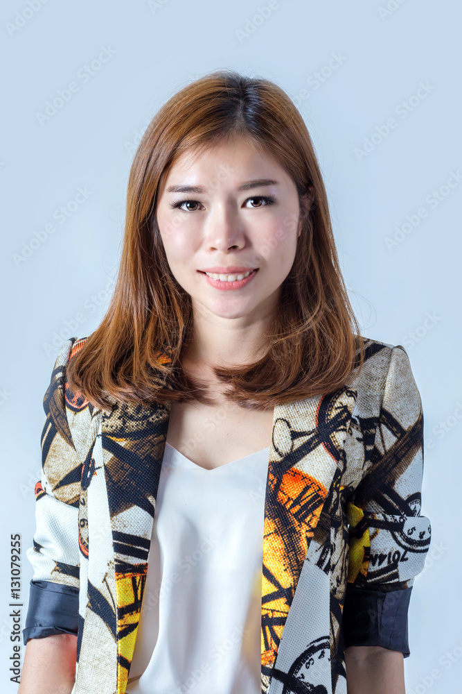 portrait of an attractive young female laughing on light grey ba