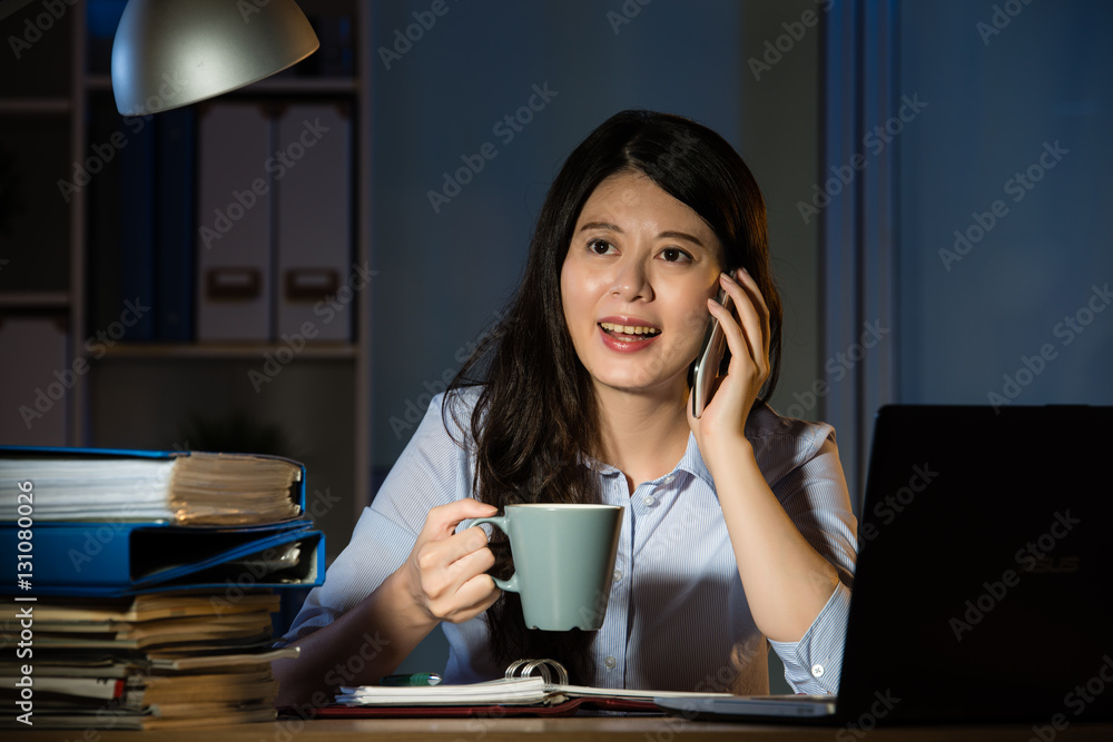 asian business woman talk on smartphone working overtime