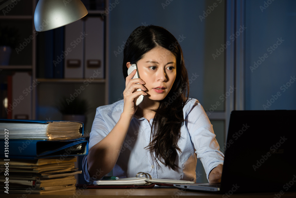 asian business woman talk on smartphone working overtime