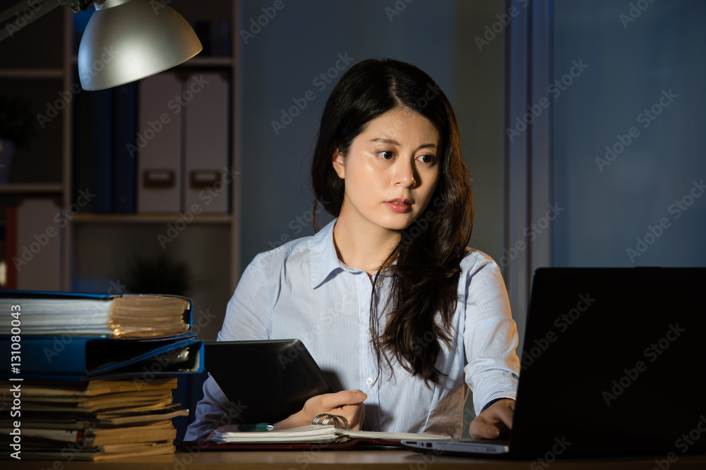 asian business woman use digital tablet working overtime