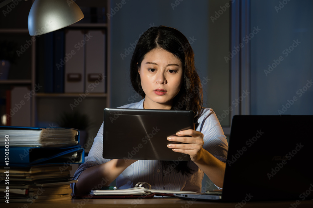 asian business woman use digital tablet working overtime