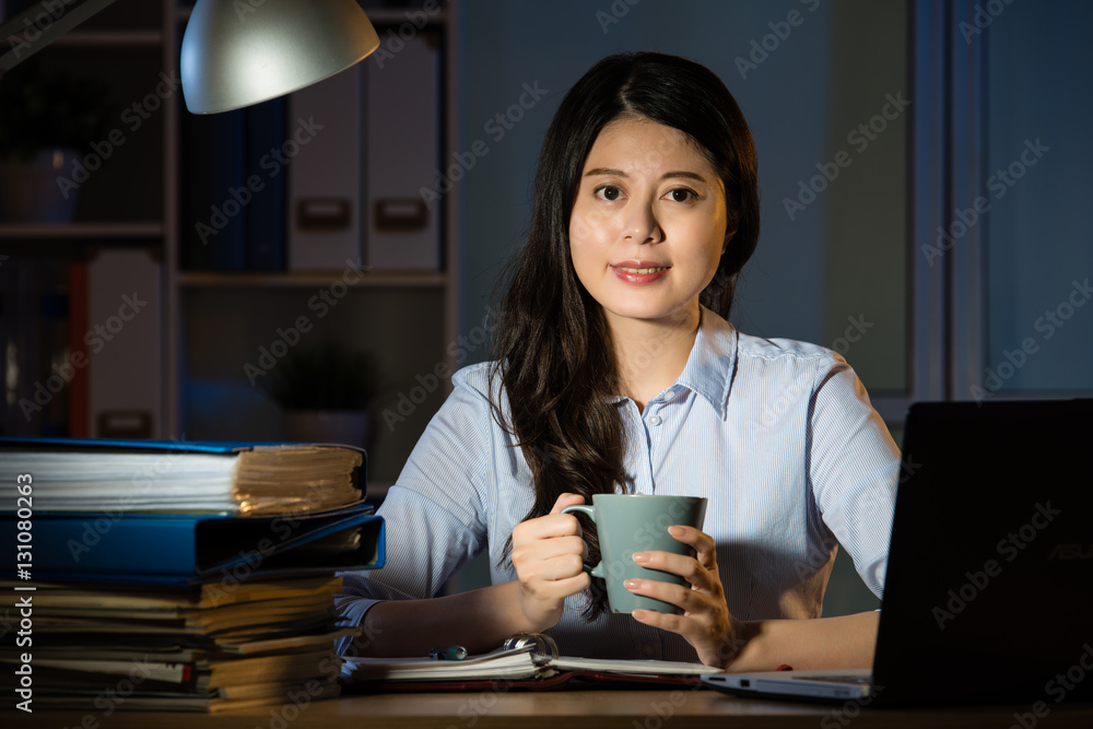 asian business woman drink coffee working overtime late night