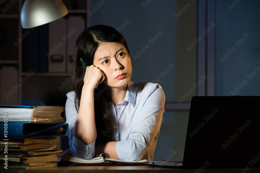 asian business woman thinking and working overtime late night