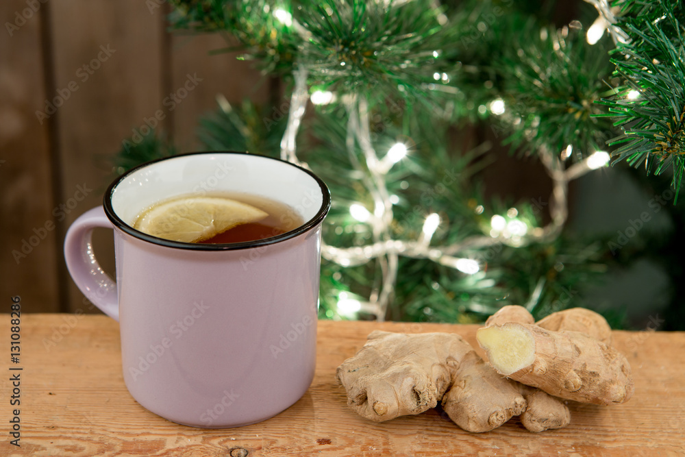 Ginger tea in a cup on wooden background