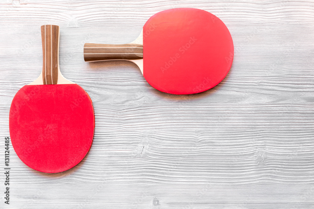 Red racket for ping pong ball wooden background top view