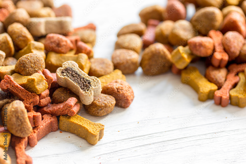 dry dog food in bulk on wooden background close up