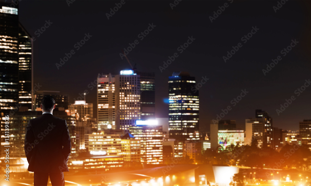 Businessman viewing night glowing city