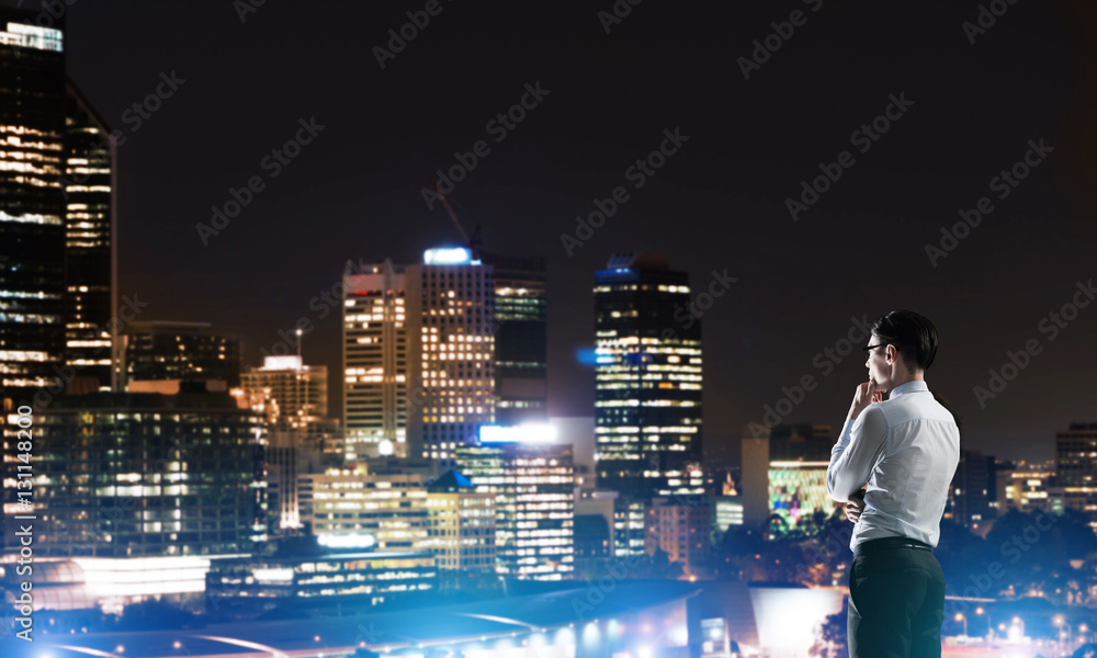 Businessman viewing night glowing city