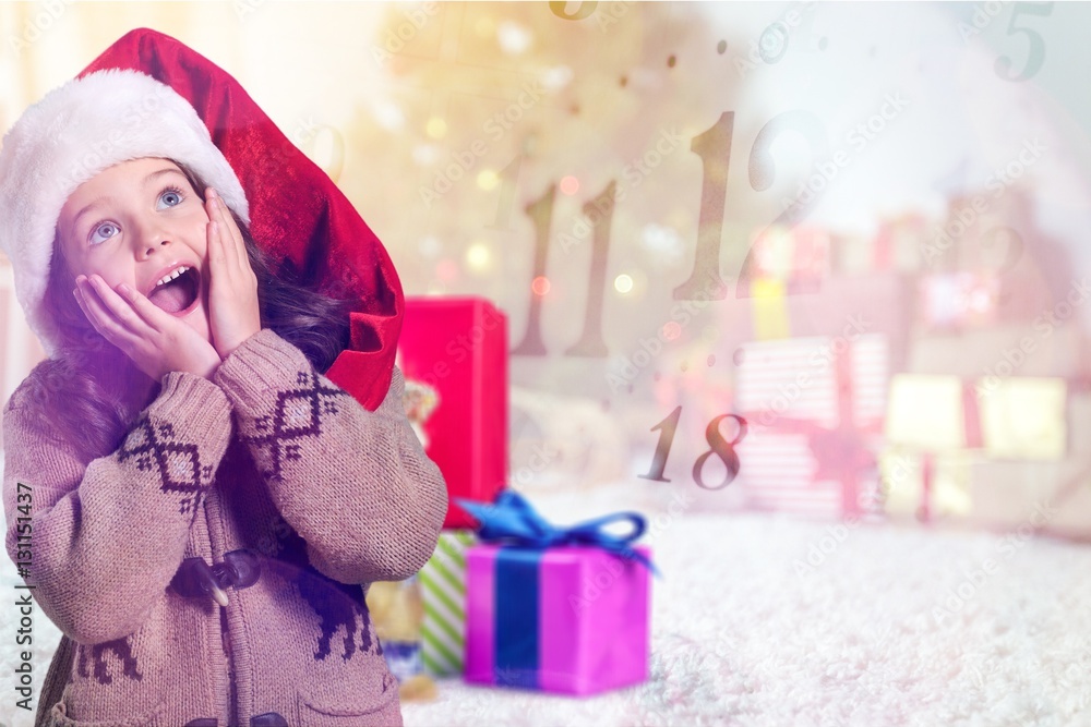 Happy child girl in a christmas hat.