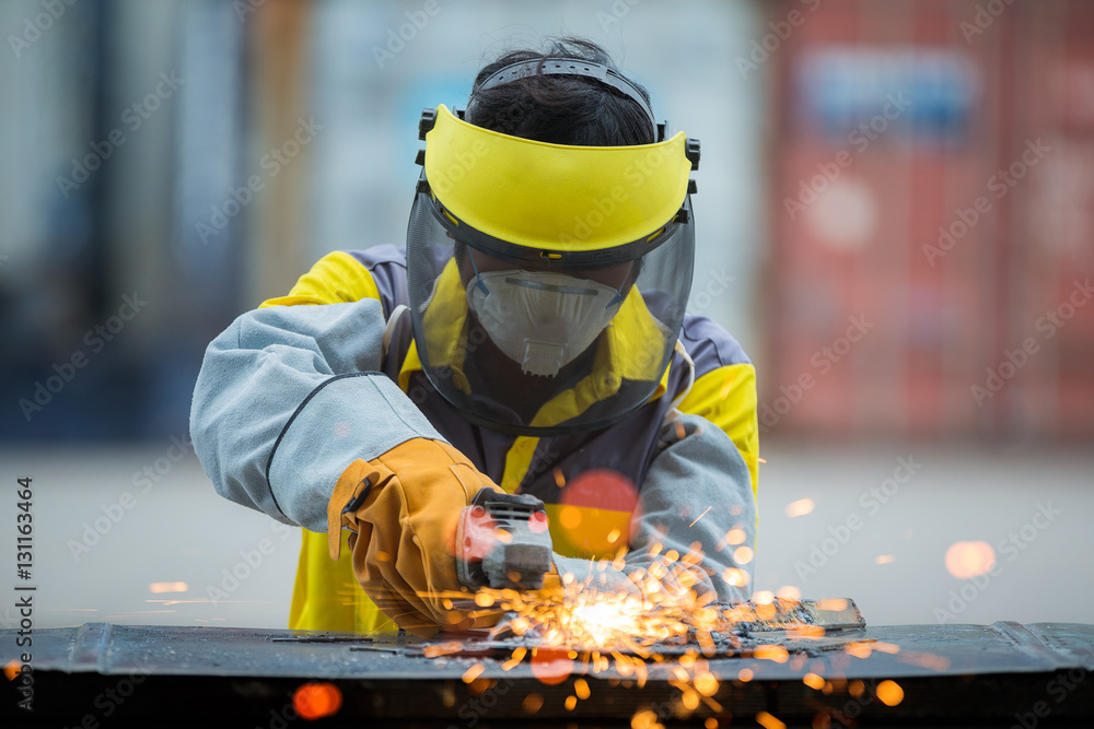 Employee grinding steel with sparks