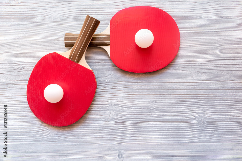 Red racket for ping pong ball wooden background top view