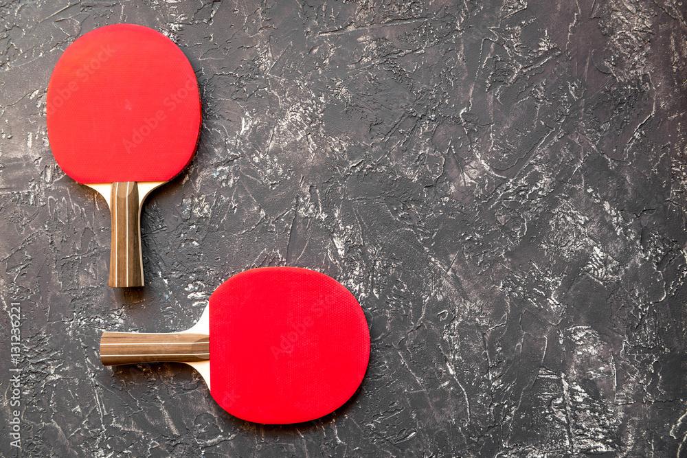 Red racket for ping pong ball gray background top view