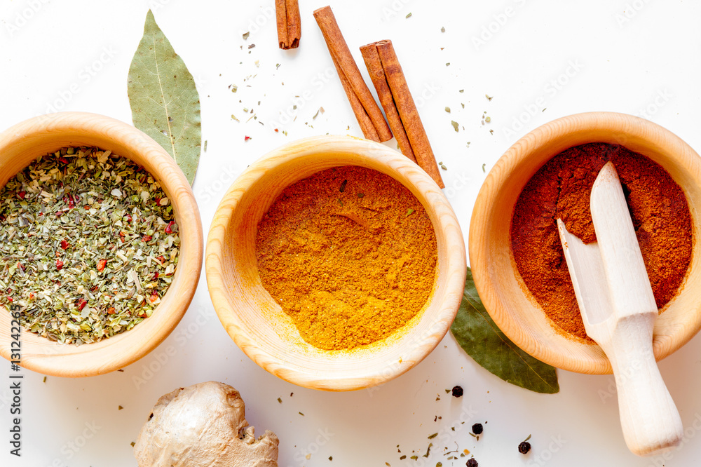 spices in wooden bowl white background top view