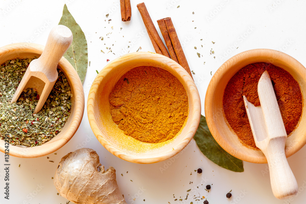 spices in wooden bowl white background top view