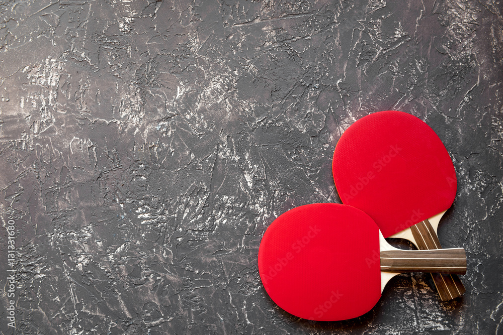 Red racket for ping pong ball gray background top view