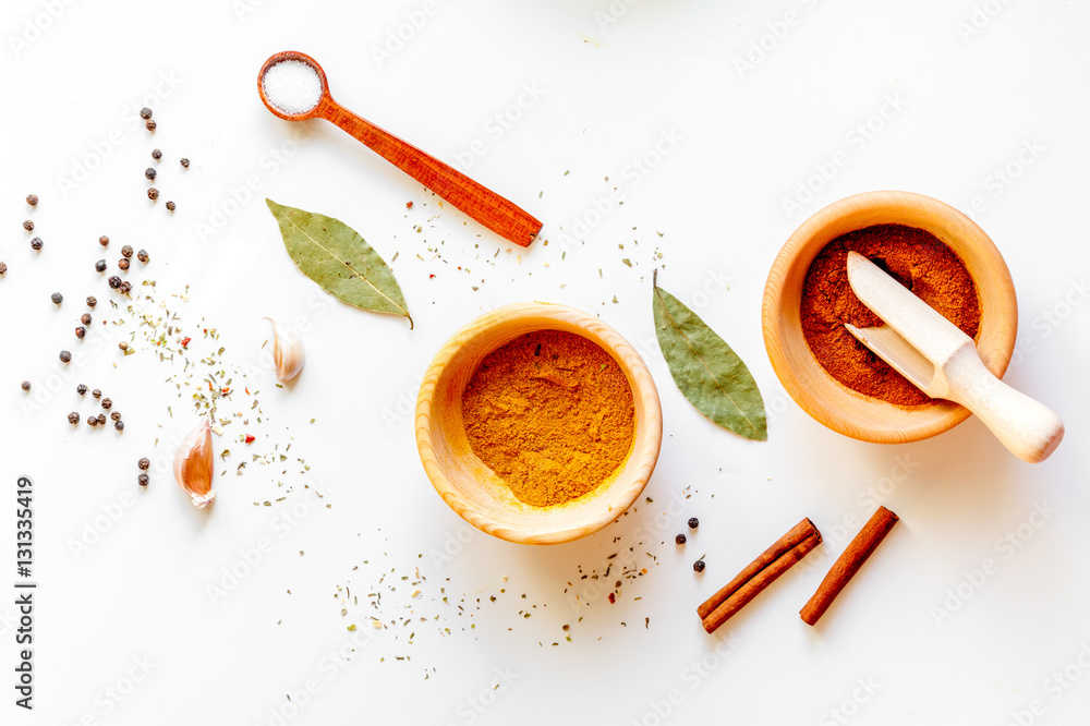 spices in wooden bowl white background top view