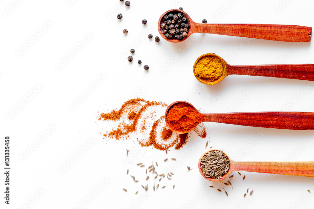 spices in wooden spoons white background top view mock up