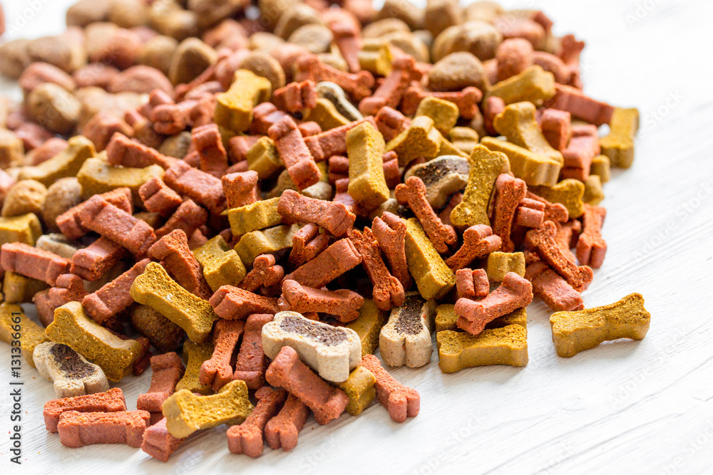 dry dog food in bulk on wooden background close up