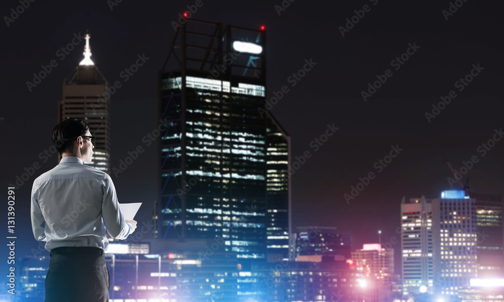 Businessman viewing night glowing city