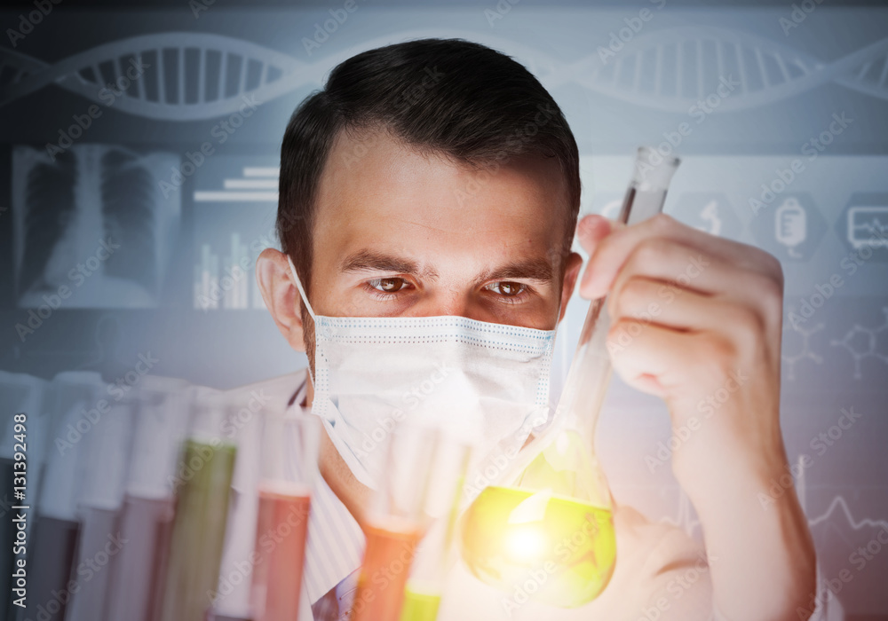 Portrait of concentrated male scientist working with reagents in laboratory