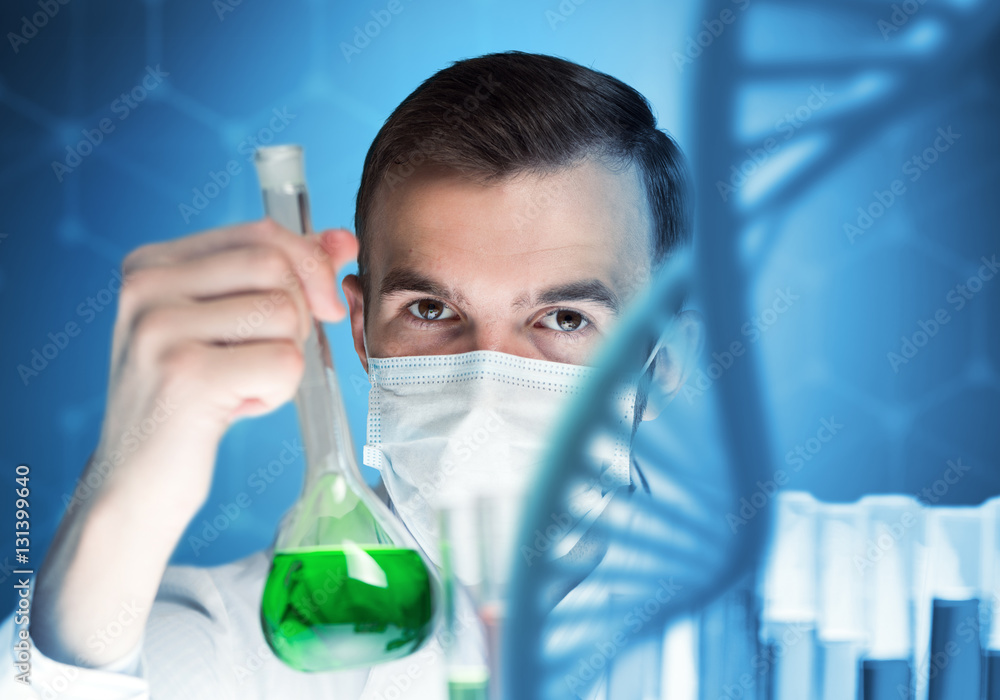 Young scientist mixing reagents in glass flask in clinical laboratory