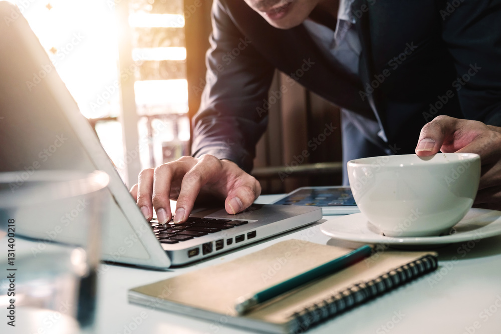 businessman hand holding coffee and working laptop with modern technology and digital layer effect a