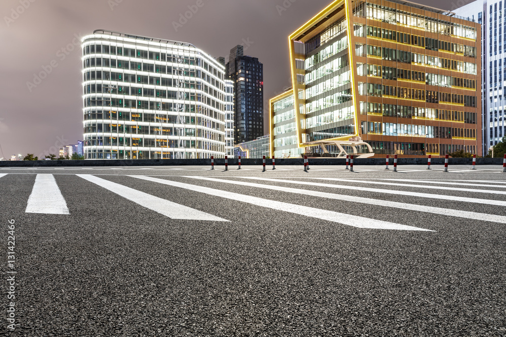 Asphalt road and modern cityscape at night in Shanghai