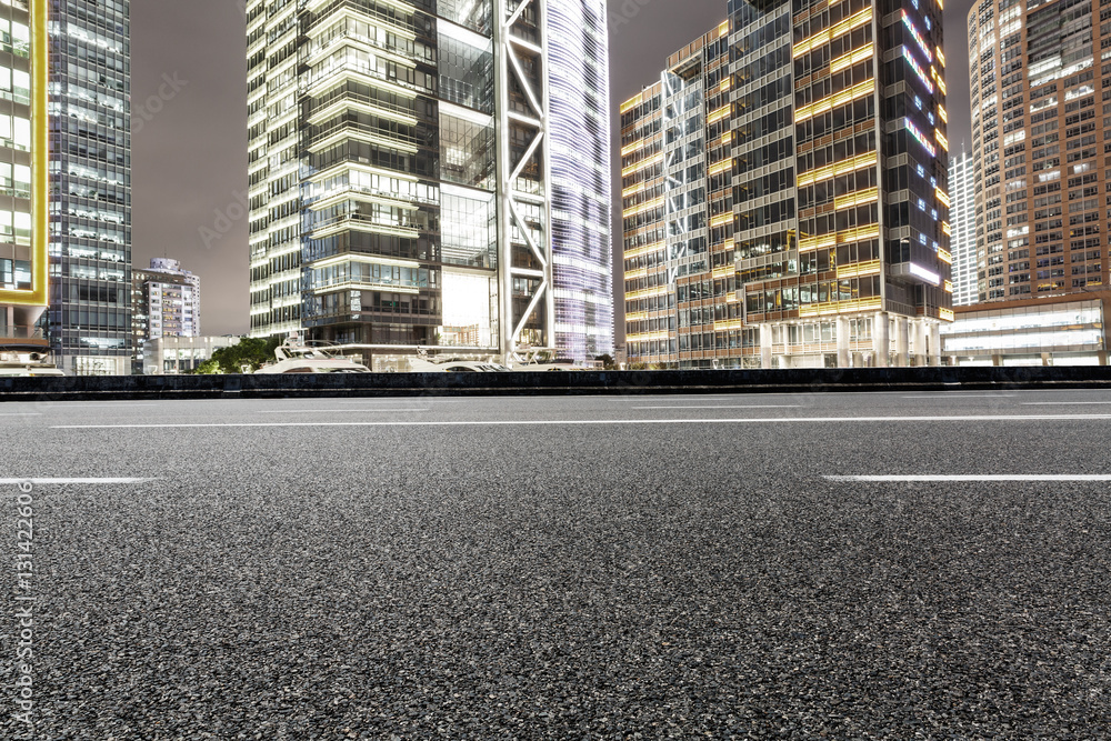 Asphalt road and modern cityscape at night in Shanghai