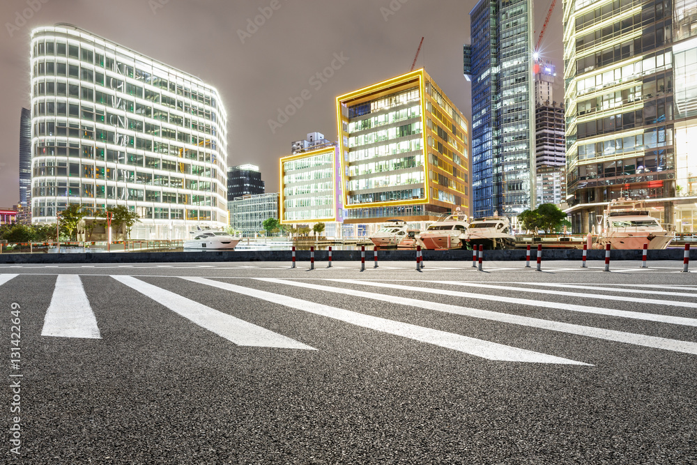 Asphalt road and modern cityscape at night in Shanghai