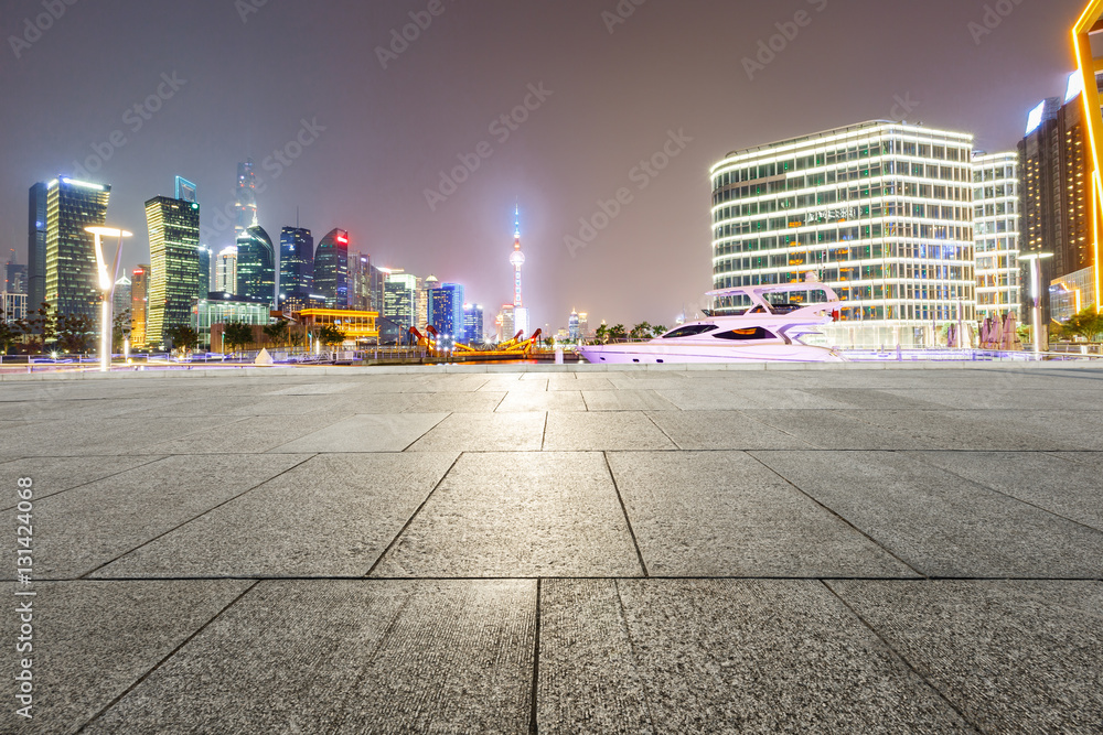 Empty floor with modern skyline and buildings at night in Shanghai