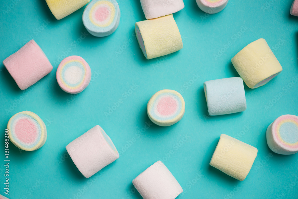 Top view of pastel colored marshmallow on a blue background. Min