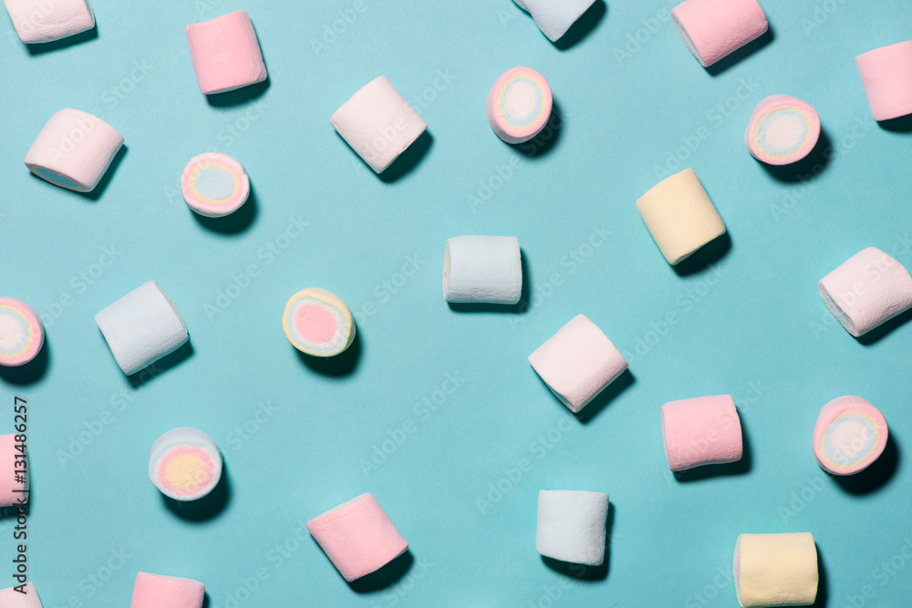 Top view of pastel colored marshmallow on a blue background. Min