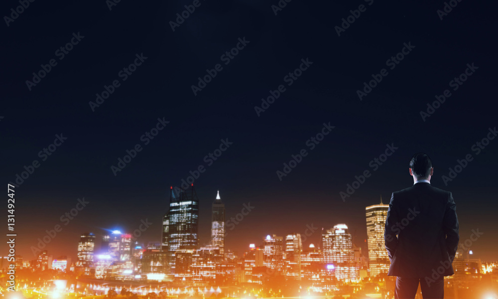 Businessman viewing night glowing city