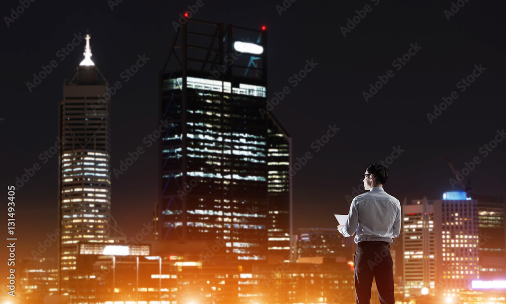 Businessman viewing night glowing city