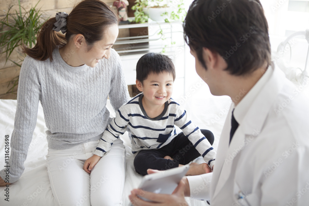 The doctor is showing the tablet to the boy