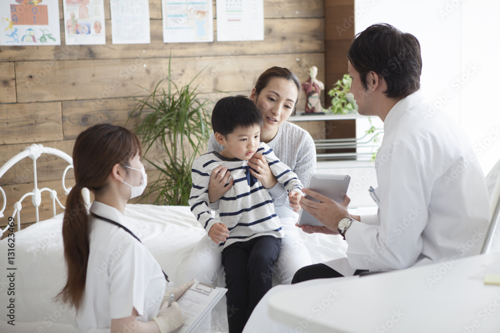 The doctor explains while showing the tablet to the boy