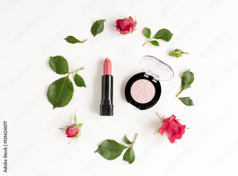 berry color decorative cosmetics with roses white background top view