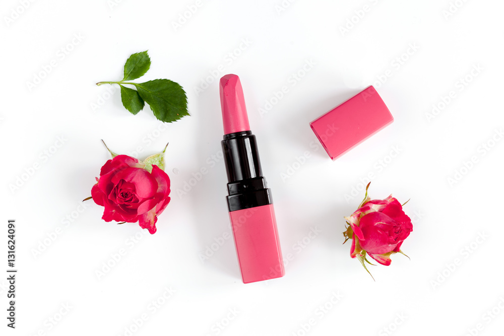 berry color decorative cosmetics with roses white background top view